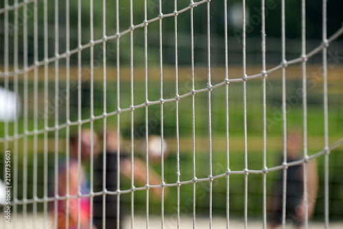 Beach volleyball net with blurred players in background