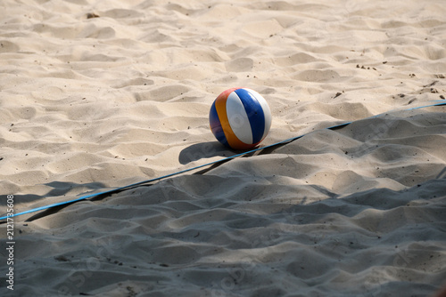 Beach volleyball on sandy court with boundary line