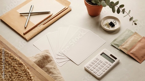 Calculator sits beside blank note cards and organized stationery items on a clean tabletop for office productivity.