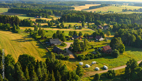 Aerial View of a Picturesque Rural Village Nestled Among Lush Green Fields and Forests.