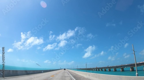 POV driving across the iconic Seven Mile Bridge in the Florida Keys with turquoise ocean, scenic coastal views and a sunny tropical atmosphere.
