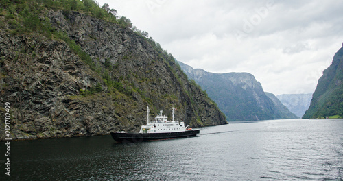 Ferry navigating sognefjord mountains and dramatic cliffs