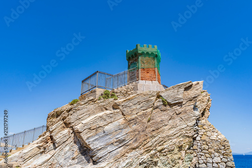Obraz na plátně Ancient tower structure in rio marina elba island on rugged cliff with blue sky