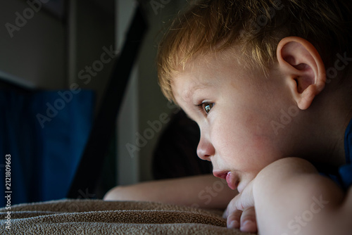 Child look from train window during family vacation