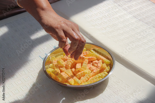 Принти на полотні a hand picking seasoned crinkle-cut French fries coated with cheese seasoning