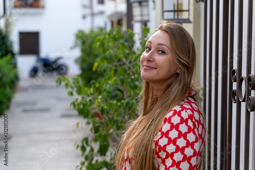 Bild auf Leinwand Smiling Young Woman Standing on Charming Spanish Street