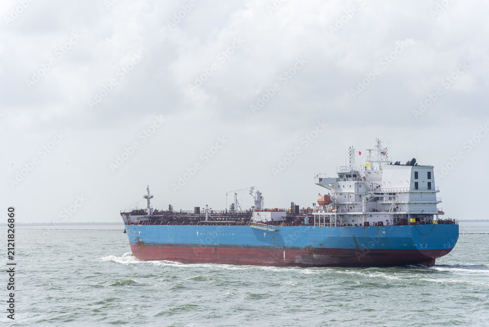 Naklejka premium Large marine tanker crossing the open sea beneath a cloudy horizon, emphasizing commercial shipping and offshore navigation.