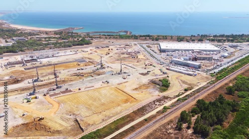 Data center building and expansion site under construction near the coastline in Portugal. Atlantic ocean. Aerial view. Moving sideways