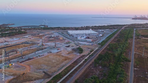 Data center building and expansion site under construction near the coastline in Portugal in evening. Atlantic ocean. Aerial view. Moving forward
