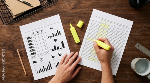 Telematics idle time report a highlighter and a fuel budget sheet on a desk