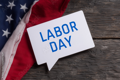 Labor Day Text on Speech Bubble Card with American Flag on Vintage Wooden Background