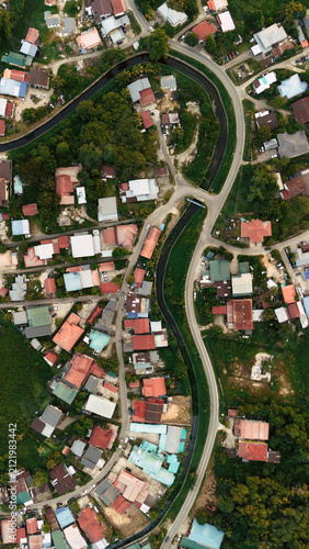 Aerial Top View of Residential Neighborhood with Curving Road and Drainage Canal in Sabah, Malaysia