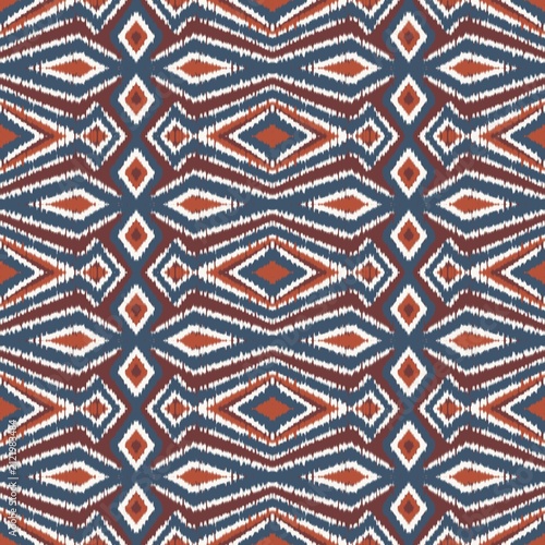 Seamless ethnic ikat pattern with bold teal blue, terracotta, and rust geometric diamond motifs on an ivory accent. Tribal fabric design perfect for bohemian prints, wallpaper, and creative decor.