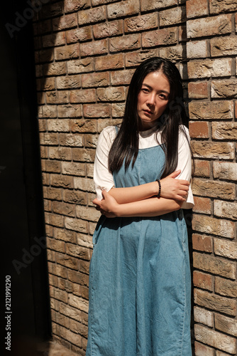 Photography Young asian woman reflecting by brick wall