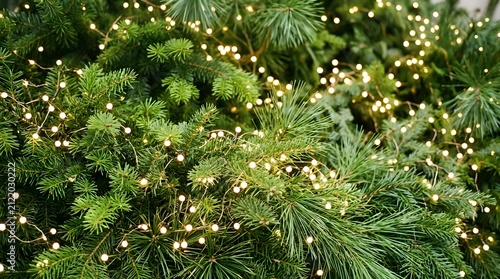 A festive christmas background featuring glowing warm fairy lights wrapped around lush green pine tree branches creating a magical holiday season atmosphere for design