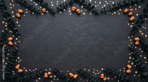 Halloween background with black leaves and acorns. Dark festive frame for seasonal greeting cards.
