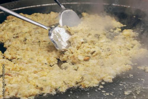 Quadro su tela Thai oyster omelette cooking on a hot pan with sizzling oil