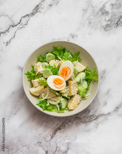 Canvastavla Potato salad with cucumbers, boiled egg and yogurt-mustard dressing on a marble