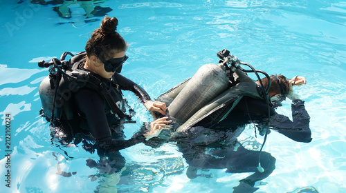Fotografie Dive instructor checking novice the diving equipment before diving