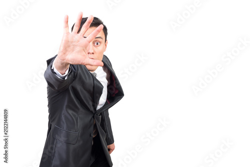 Foto Scared handsome man demonstrating stop gesture