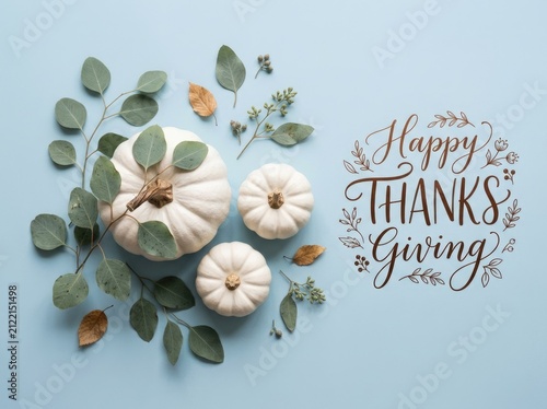 Flat lay composition with white pumpkins and eucalyptus leaves for a festive happy thanksgiving holiday greeting