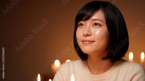 Portrait of young asian woman lit by warm glowing candle lights with portrait