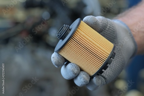 Auto parts. Replacing the oil filter in the car engine.An auto mechanic demonstrates a new oil filter. Inspection and control of the complete condition of the filter before installation.