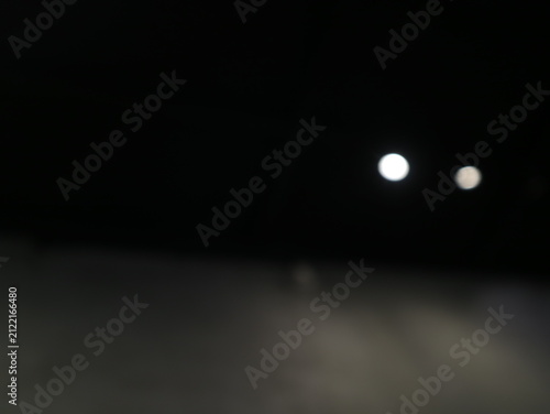 Canvastavla Abstract blurred background with glowing white light circles in the dark night
