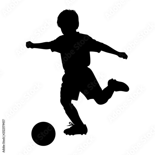 A black silhouette vector illustration of a young child kicking a soccer ball on a white background.