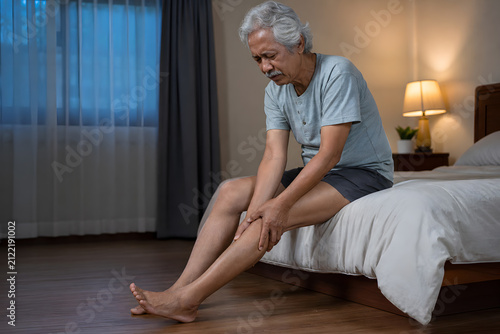 Older Asian man suffering nighttime calf cramp