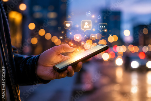 Hand Holding Smartphone With Glowing Communication Icons