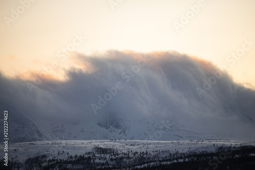 Bild auf Leinwand view of a snowy mountain in Troms, Norway, as golden winter sunrise