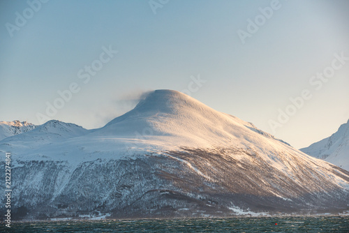 Bild auf Leinwand Malangen Fjord towards a snow covered mountain glowing in warm winter