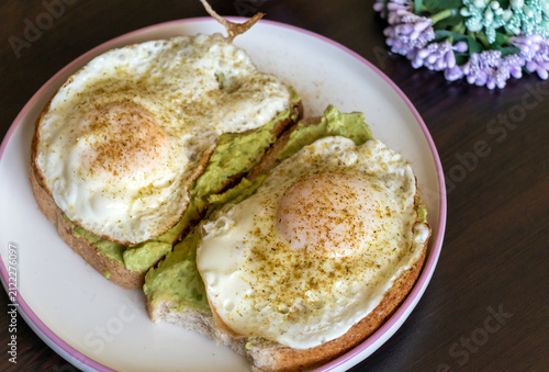 Healthy homemade breakfast with avocado toast and fried eggs on a plate