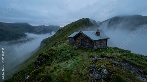 Misty mountain landscape with ancient stone cottage nestled in lush green hillside during overcast weather mountain landscape hillside overcast vegetation