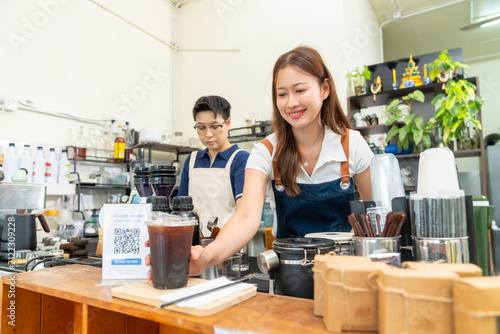 Cuadro en lienzo Female barista serving fresh iced coffee to customer at cafe counter, profession