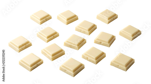 Close-up view of multiple small, square pieces of white chocolate arranged on a clean white background, showcasing their creamy texture and light color.