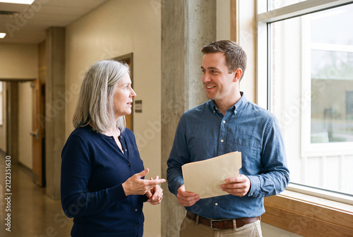 Two teachers talking together school hallway lessons people colleagues staff education