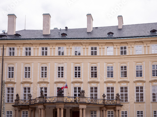фотографія New Royal Palace at Prague Castle, Prague, Czechia, with historic ceremonial balcony, sculptures, Czech flag and elegant palace facade in the Third Courtyard