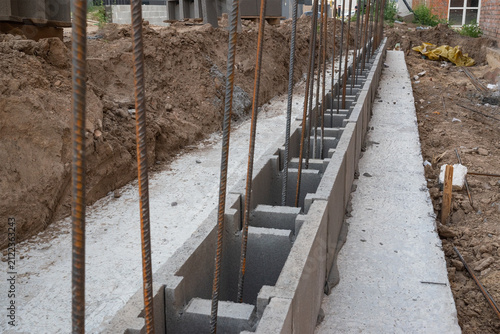 Konstfotografi Concrete masonry blocks with steel reinforcement bars prepared for reinforced concrete wall construction on a building foundation