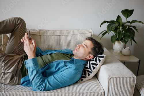 Man Lying on Sofa Using Smartphone for Online Dating Apps
