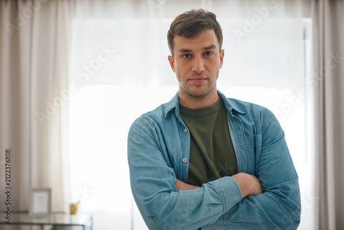 Portrait of a man standing in his modern apartment