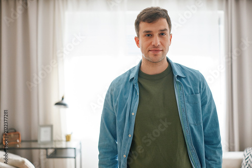 Portrait of a man standing in his modern apartment