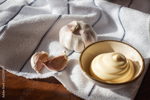 Obraz na plátne Mayonnaise with Fresh Garlic on Kitchen Towel and Wooden Table