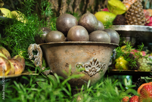 Fresh passion fruit in a vintage metal bowl at a buffet