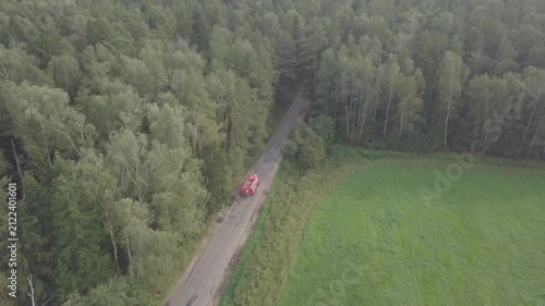 Smooth forward drone flight over forest edge road