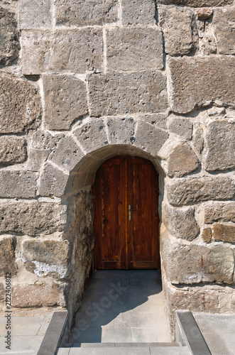 Architectural detail of an old wooden door framed by a historical stone archway at Kayseri Castle, Kayseri, Turkey
