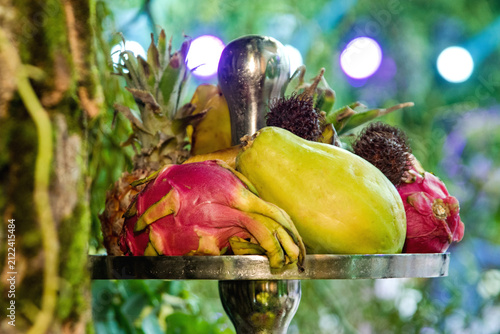 Exotic tropical fruits on a silver tiered stand at a catered event