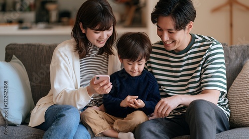 Happy family using smartphone together while relaxing on living room sofa