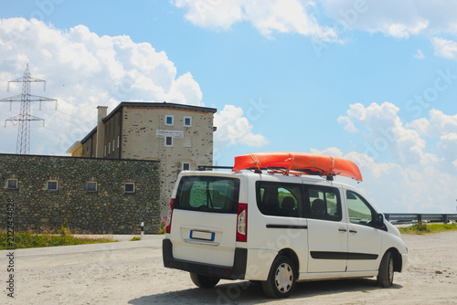 Фотография Car van with kayak on top roof against mountain nature